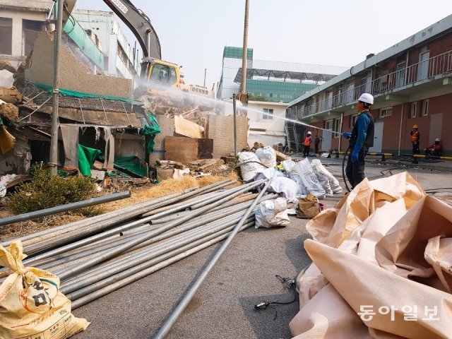 27일 건물 철거 현장에서 한 근로자가 먼지를 가라앉히기 위해 물을 뿌리고 있다. 조유라 기자 jyr0101@donga.com