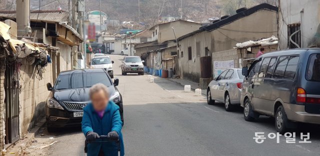 26일 서울 노원구 ‘백사마을’에서 한 할머니가 마스크를 쓰지 않은 채 걸어가고 있다. 김정훈 기자 hun@donga.com