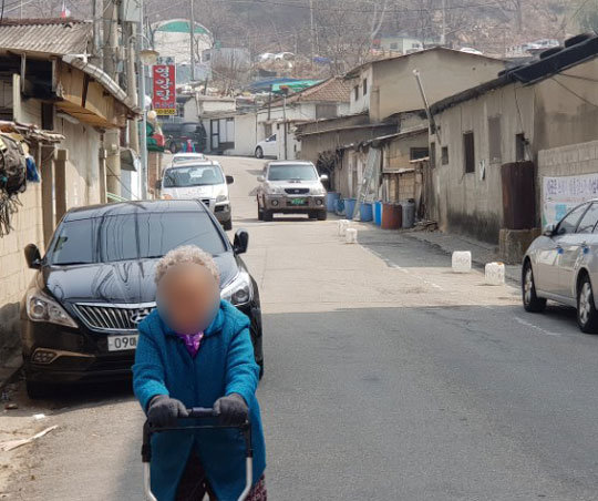 숨막히는 외출 26일 서울 노원구 백사마을에서 한 할머니가 마스크를 쓰지 않은 채 걸어가고 있다.