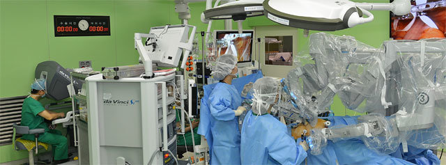 김남규 연세암병원 대장항문외과 교수(왼쪽)가 콘솔(로봇 조종기)에 앉아 로봇 수술을 시행하고 있다. 김 교수의 지시에 따라 나머지 보조 의료진은 로봇팔을 교체하는 등 수술을 돕는다. 연세암병원 제공