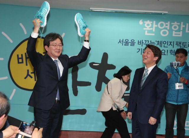 바른미래당 유승민공동대표가  8일 오후 서울 종로구 동일빌딩에 마련한 안철수 선거캠프인 ‘미래캠프’개소식에서 축사를 한후 민트색 운동화를 안철수 바른미래당  인재영입위원장 겸 서울시장 예비후보에게 전달하고 있다.