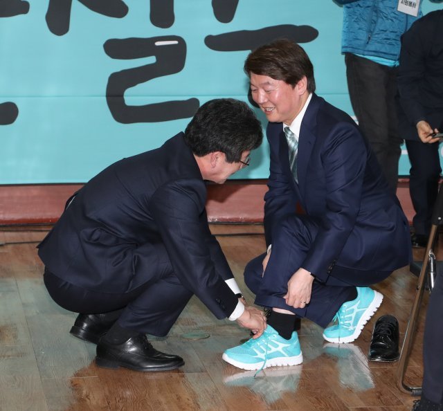 바른미래당 유승민공동대표가  8일 오후 서울 종로구 동일빌딩에 마련한 안철수 선거캠프인 ‘미래캠프’개소식에서 축사를 한후 민트색 운동화를 안철수 바른미래당  인재영입위원장 겸 서울시장 예비후보에게 신겨주고있다.민트색은 바른미래당의 당  로고색이다.