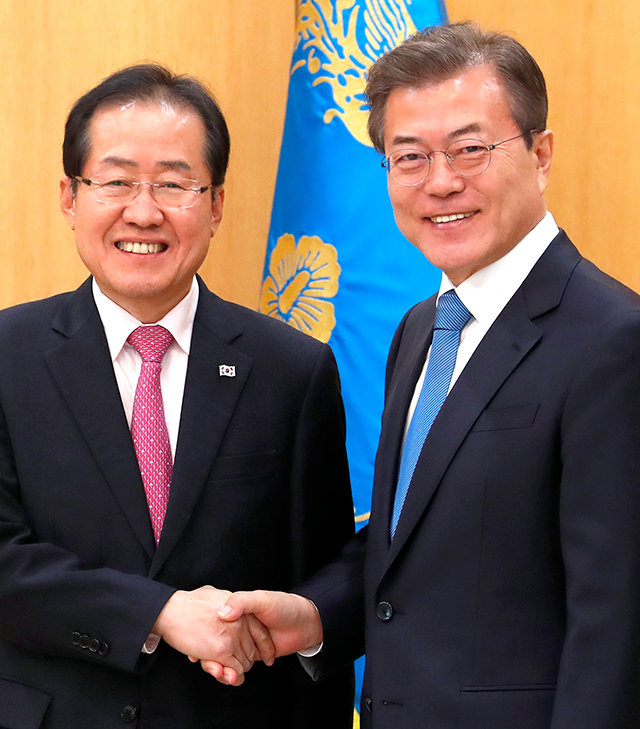 80분간 靑회동 문재인 대통령(오른쪽)과 홍준표 자유한국당 대표가 13일 청와대에서 만나 악수하고 있다. 문 대통령이 제1야당 대표와 단독 회담을 가진 것은 처음이다. 홍 대표 양복 상의에 태극기 배지가 눈에 띈다. 청와대 제공