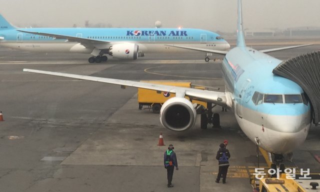 김포공항에 서 있는 대한항공 보잉 737 항공기. 엔진 앞에 놓인 원뿔과 지상 조업자를 보면 이 비행기 높이를 가늠할 수 있습니다. 동아일보DB