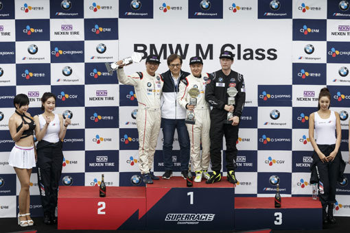 BMW M클래스 첫 대회 우승의 역사를 쓴 현재복 선수(왼쪽 세 번째)와 BMW 그룹 코리아 김효준 대표이사 회장(왼쪽 두 번째)이 포디엄에 올라 기념 촬영을 하고 있다. 사진제공｜BMW코리아