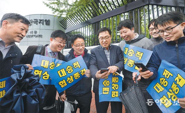 한국GM 협력사도 “한숨 돌렸다” 한국GM 노사가 23일 임금 및 단체협약에 잠정 합의했다. 인천 부평구 한국GM 부평공장 서문 인근에서 협상 타결을 촉구하며 시위를 벌이던 협력업체 직원들이 노사 합의 소식을 스마트폰으로 보고 있다. 인천=장승윤 기자 tomato99@donga.com