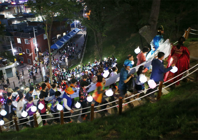 지난해 5월 대구 서구 비산동에서 열린 달성토성마을 골목축제에 참가한 시민들이 등불을 들고 토성 둘레길을 오르고 있다. 대구 서구 제공