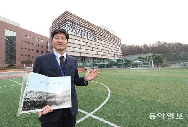 지난해 ‘80년 안국동 시대’를 마감하고 강남구 자곡동으로 이전한 풍문고의 김길동 교장이 옛날 졸업앨범을 들고 운동장에 섰다. 학교 운동장이 학생으로 꽉 찬 앨범 속 사진은 1970년대 풍문여고 모습이다. 김재명 기자 base@donga.com