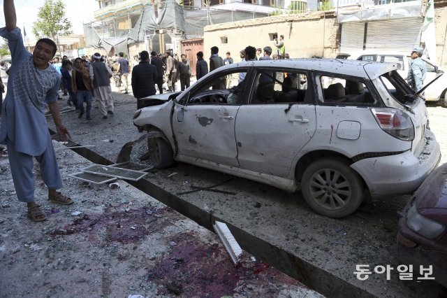 People gather outside a voter registration center which was attacked by a suicide bomber in Kabul, Afghanistan, Sunday, April 22, 2018. Gen. Daud Amin, the Kabul police chief, said the suicide bomber targeted civilians who had gathered to receive national identification cards. (AP Photo/ Rahmat Gul)