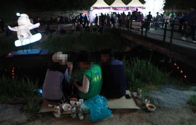 1일 오후 서울 노원구 중계동 당현천 일대에서 열리는 ‘노원 등축제’ 먹거리 부스 주변으로 술판이 벌이지고 있다.