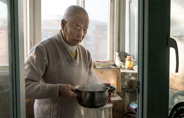 85세의 나이에 ‘나를 입양해 달라’고 쓴 전단을 만들어 붙인 중국 남성 한쯔청 씨가 살아생전 자신의 집에서 요리를 하고 있다. 사진 출처 워싱턴포스트