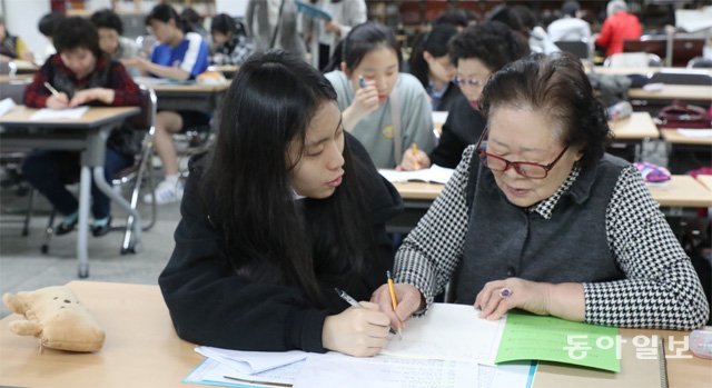 12일 서울 마포구 일성여중고 다목적실에서 ‘과외 선생님’ 신미성 양(왼쪽)이 ‘만학도 제자’ 김송자 할머니에게 영어를 가르쳐주고 있다. 김동주 기자 zoo@donga.com