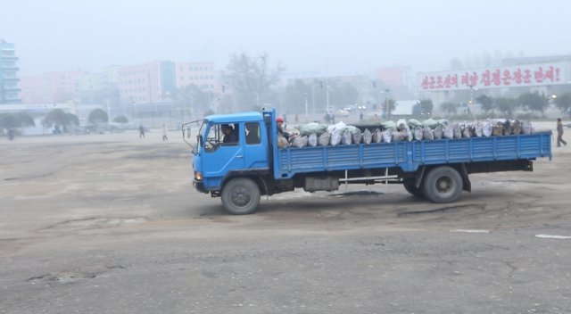 나선시 인근 다리(위)와 짐을 한 가득 싣고 시내의 비포장도로를 달리는 트럭.