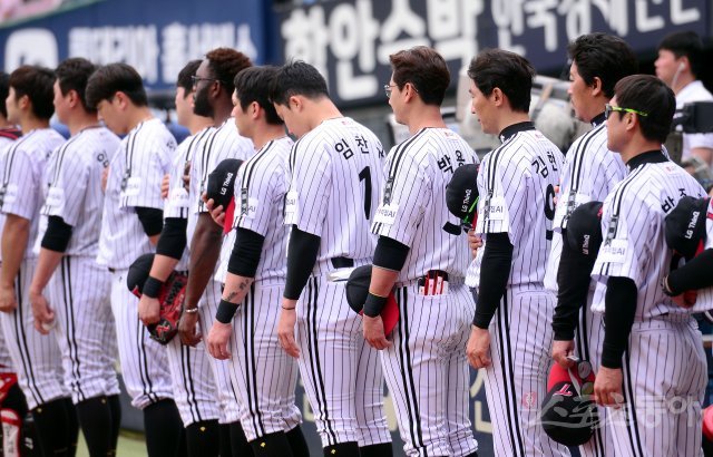 20일 서울 잠실야구장에서 ‘2018 신한은행 MY CAR KBO리그’ 한화이글스와 LG트윈스 경기가 열렸다. LG 선수들이이 LG그룹 구본무 회장의 별세를 추모하기 위해 검은 리본을 달고 국민의례를 하고 있다. 잠실 | 김종원 기자 won@donga.com