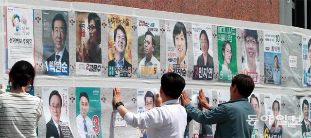 6·13지방선거의 공식 선거운동 첫날인 31일 서울 송파구 지하철 2호선 잠실새내역 인근에서 주민센터 직원들이 나와 선거 벽보를 붙이고 있다. 박영대 기자 sannae@donga.com