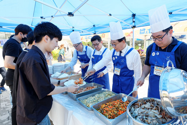 7일 서울 서대문구 연세대에서 김용학 총장(오른쪽에서 두 번째)을 비롯한 교수들이 학생들에게 음식을 나눠주고 있다. 연세대는 ‘책거리’ 행사의 하나로 이날 재학생 500명에게 식사를 제공했다. 연세대 제공