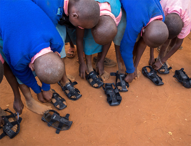 케냐 어린이들이 기부받은 ‘자라나는 신발’을 신어보고 있다. 사진 출처 비코즈 인터내셔널