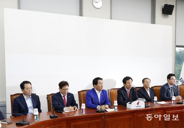 당 로고-구호 없는 ‘백지 회의장’ 자유한국당 김성태 대표 권한대행(오른쪽에서 세 번째)이 2일 
국회에서 열린 당 원내대책회의에서 발언하고 있다. 통상 당의 로고와 구호를 선전하는 회의장 뒤편이 아무런 문양 없이 흰 벽 그대로
 남아 있어 눈길을 끈다. 장승윤 기자 tomato99@donga.com