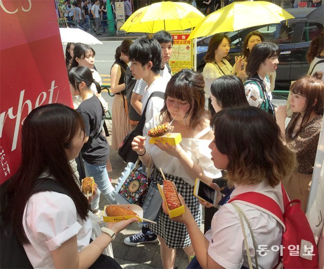 1일 낮 일본 도쿄 신오쿠보에서 일본 여성들이 치즈핫도그를 먹고 있다. 신오쿠보는 최근 치즈닭갈비에 이어 치즈핫도그가 인기를 얻으며 사람들이 몰리고 있다. 도쿄=김범석 기자 bsism@donga.com