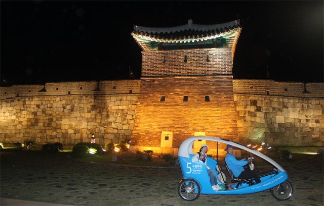 6일부터 야간 운행되는 수원시 자전거택시가 수원화성 앞을 지나고 있다. 수원시 제공
