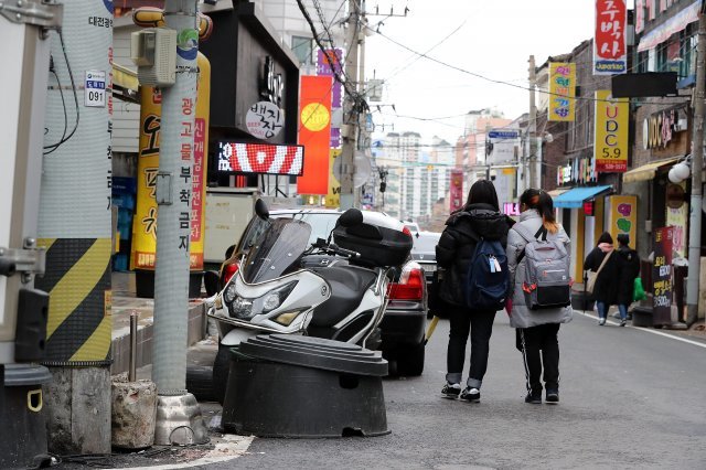 대전의 한 어린이 보호구역에서 두 어린이가 도로에 나온 적치물과 광고판들을 피해 걷고 있다. 동아일보 DB