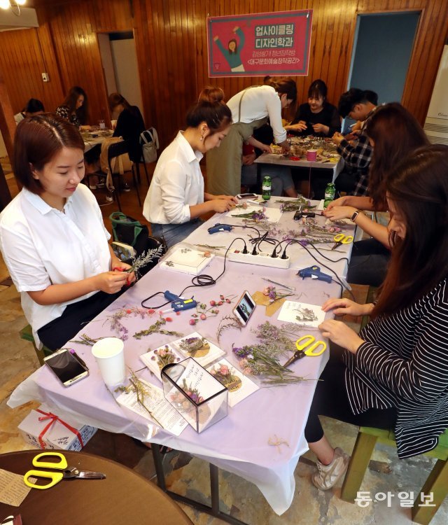 5일 대구 중구의 대구문화예술창작공간에서 청년들이 말린 꽃과 버려진 포장재를 이용해 엽서를 만들고 있다. 이 수업은 대구 청년센터의 청년학교 ‘딴길’의 ‘업사이클링디자인학과’ 일환으로 진행됐다. 대구=최혁중 기자 sajinman@donga.com