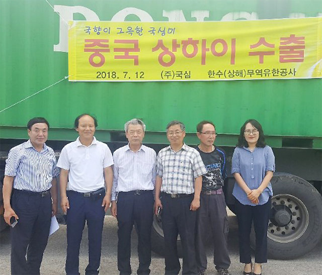 국화 전문 브랜드인 ㈜국심의 전계식 대표(왼쪽에서 세 번째) 등이 중국으로 수출하는 쌀을 컨테이너에 실은 뒤 기념촬영을 하고 있다. ㈜국심 제공
