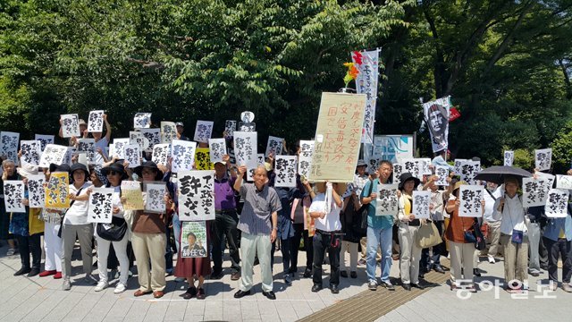 3일 낮 일본 도쿄 국회의사당 앞에서 100여 명이 ‘아베 정치를 용서하지 않아’라고 적힌 포스터를 들고 항의 시위를 벌이고 
있다. 앞줄 왼쪽에서 두 번째가 ‘포스터 집회’를 만든 여성 작가 사와치 히사에 씨다. 도쿄=김범석 특파원 
bsism@donga.com