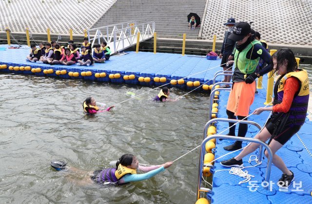 강사와 함께 물이 든 페트병을 끈에 묶어 던진 후 물에 빠진 사람을 구하는 방법을 학생들이 실천하고 있다. 김재명 기자 base@donga.com