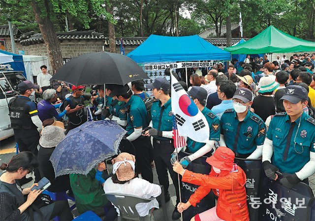 대한문 앞 두 분향소… 긴장감 ‘팽팽’ 서울 중구 덕수궁 대한문 앞에 쌍용자동차 해고 노동자 출신 
김주중 씨 분향소와 연평해전·천안함 용사 분향소가 나란히 세워지면서 양측의 대치가 길어지고 있다. 4일 쌍용차 노조와 보수단체가 
대한문 앞에서 각각 집회를 벌이자 충돌을 막기 위해 경찰관들이 양측 사이에 서 있는 모습. 원대연 기자 yeon72@donga.com