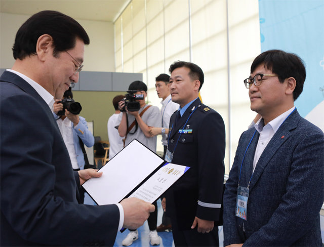 이용섭 광주시장이 18일 제7회 인구의 날 기념행사에서 김정현 롯데백화점 광주영업부문장(오른쪽)에게 유공 표창을 주고 있다. 롯데백화점 광주점 제공