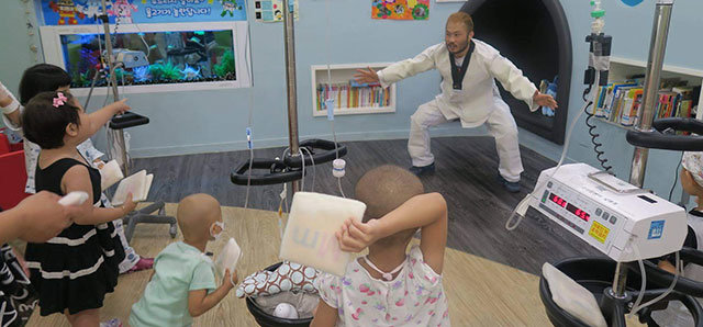 종합격투기 선수인 김형수 씨가 서울성모병원에서 백혈병, 소아암을 앓고 있는 어린이들에게 두 팔을 벌리는 동작을 함께 하며 운동을 시켜주고 있다. 한국메이크어위시재단 제공