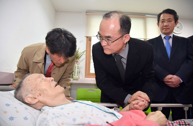 문무일 검찰총장이 지난 3월 20일 부산 수영구의 한 요양병원에 입원 중인 고 박종철 열사의 부친 박정기 씨를 찾아 손을 잡고 있다. 문 총장은 “잘못을 되풀이하지 않겠다”며 검찰의 과거사에 대해 사과했다. 사진=사진공동취재단