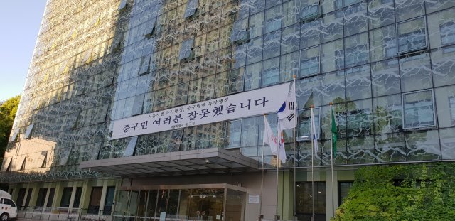 30일 서울 중구청 잔디광장 앞에 내걸린 사과 플래카드와 수거된 그늘막. 이날 중구는 기자회견을 열어 “서울시 간부의 요구로 다른 곳보다 시청 앞에 그늘막이 먼저 설치됐다”며 구정을 반성한다고 밝혔다. 중구청 제공