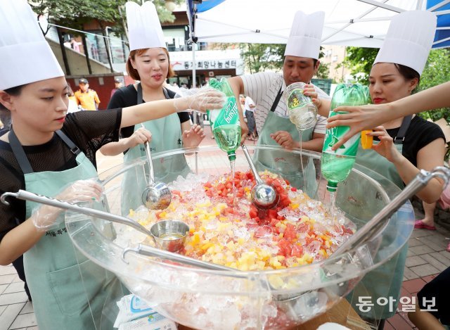 KT 직원들이 7일 오후 서울 동자동 새꿈어린이 공원에서 주민들에게 나눠줄 화채를 만들고 있다.