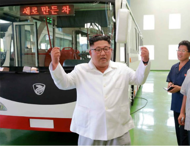 김정은 북한 국무위원장이 4일 북한의 기술로 만들었다는 새 버스 앞에 서서 두 손을 들고 기뻐하고 있다. 사진 출처 조선중앙통신