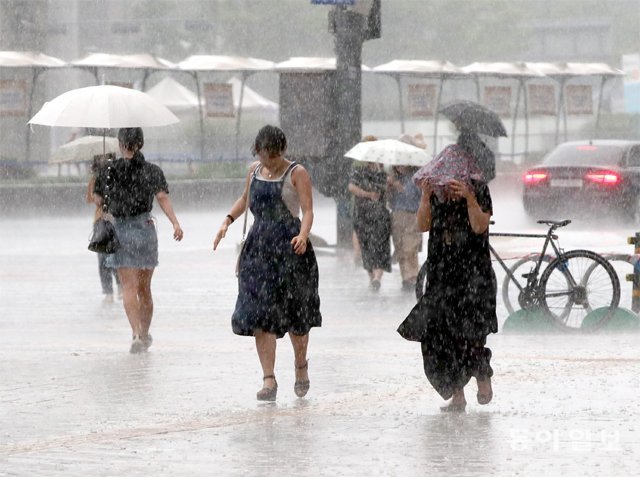 짓궂은 소나기 12일 오후 6시경 서울 종로구 세종대로 사거리 일대에서 시민들이 갑자기 내리는 비를 피하고 있다. 잠깐 소나기가 오긴 했지만 태풍 ‘야기’가 한반도를 비켜가면서 이번 주에도 폭염이 지속될 것으로 보인다. 최혁중 기자 sajinman@donga.com