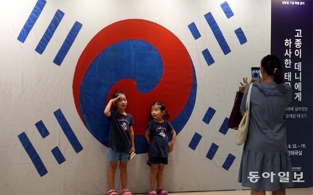 가장 오래된 ‘데니 태극기’ 앞에서 찰칵 13일 서울 용산구 국립중앙박물관을 찾은 관람객들이 우리나라에
 남아 있는 가장 오래된 국기인 ‘데니 태극기’ 포토존에서 기념사진을 찍고 있다. 고종은 1890년 자신의 뜻에 따라 청나라의 
부당한 간섭을 비판했던 미국인 외교 고문 ‘데니’에게 이 태극기를 하사했다. 장승윤 기자 tomato99@donga.com