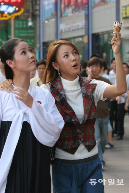 가수 이효리(오른쪽) 씨와 북한 무용수 조명애 씨가 2005년 9월 12일 중국 상하이에서 아이스크림을 먹으며 길거리를 구경하고 있다. [동아DB]