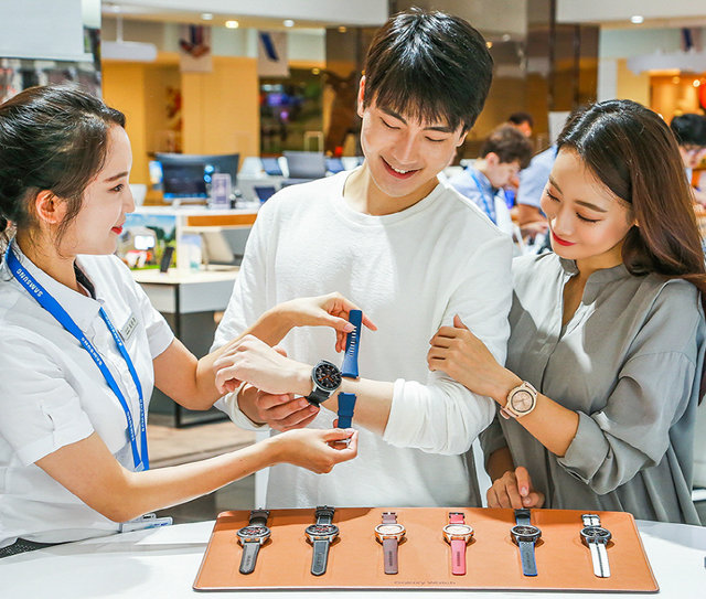 26일 서울의 한 전자제품 매장에서 모델들이 새로 출시된 갤럭시워치를 착용해보고 있다. 블루투스 모델은 27일, LTE 모델은 31일부터 살 수 있다. 삼성전자 제공