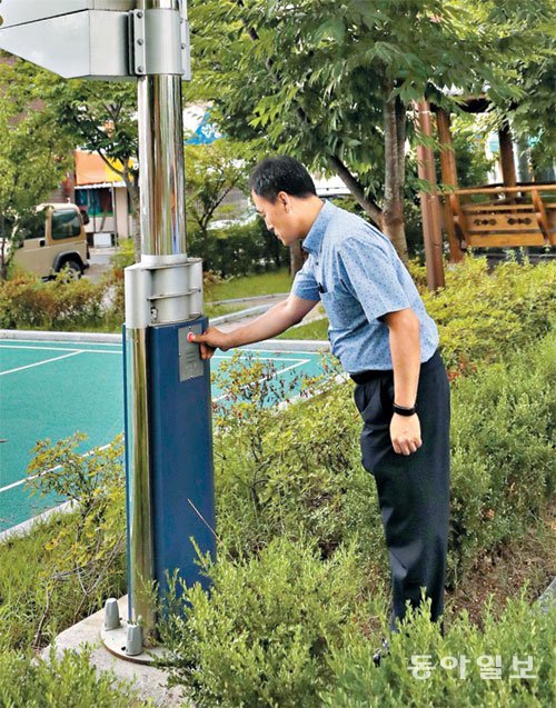 정은표 경산시청 정보통신과 계장이 계양동 근린 공원에 설치된 CCTV 기둥의 버튼을 눌러 통합관제센터와 연락이 잘되는지 알아보고 있다. 경산=장승윤 기자 tomato99@donga.com