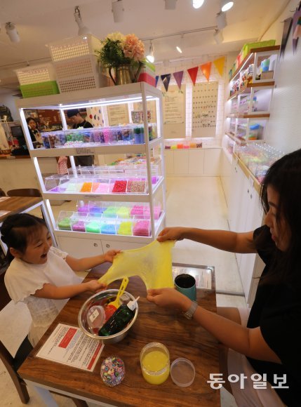 지난달 31일 서울 마포구 슬라임 카페 ‘릴리데이지’를 찾은 어머니와 딸이 슬라임을 넓게 펼치며 놀고 있다. 안철민 기자 acm08@donga.com