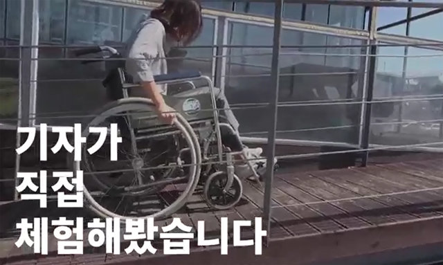 본보 김예윤 기자가 서울 이촌한강공원 편의점에서 장애인 등 노약자의 출입을 위해 만든 경사로를 휠체어를 타고 체험하고 있다.