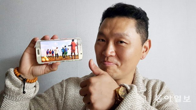 양동근 씨가 올 7월 카메룬 응가운데레 지역을 방문했을 때 아이들과 찍은 휴대전화 사진을 들어 보이고 있다. 박영대 기자 sannae@donga.com