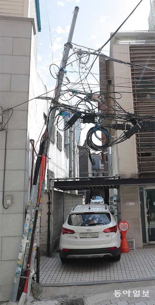 서울 중구의 한 골목에 세워진 전봇대. 통신선이 얽힌 채 오른쪽으로 10도가량 기울어 있다. 원대연 기자 yeon72@donga.com