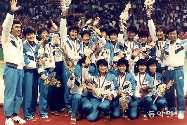 여자 핸드볼 대표팀이 88 서울 올림픽 우승 축하 기념 사진을 찍고 있다. 고병훈 감독(왼쪽)이 이끈 여자 핸드볼 대표팀은 한국 구기 종목 사상 처음으로 올림픽 금메달을 목에 걸었다. 동아일보DB