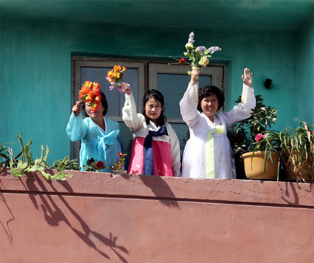 아파트선 환영 꽃다발 18일 평양 순안공항에서 평양 시내로 향하는 길가의 한 아파트에서 한복 차림의 여성들이 꽃을 흔들고 있다. 평양=사진공동취재단