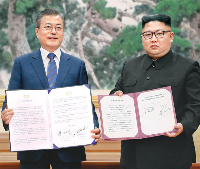 평양선언문 공개… 靑 “남북정상 실질적 종전선언” 문재인 대통령과 김정은 북한 국무위원장이 19일 평양
 백화원 영빈관에서 9월 평양공동선언에 서명하고 이를 펼쳐 보이고 있다. 사진을 확대해 보면 문서 하단에 남측은 1쪽과 4쪽이, 
북측은 1쪽과 7쪽이 표기되어 있다. 북측 문서 크기가 남측보다 작아 3쪽 더 많다. 1쪽을 비교해보면 내용은 거의 같고 남측이 
‘지향과 여망’으로 표현한 것을 북측이 ‘지향과 념원’으로 표현하는 등 일부 표현에 차이가 있다. 평양=사진공동취재단·원대연 기자
 yeon72@donga.com