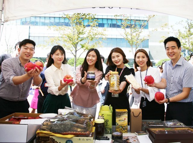 삼성전자 임직원들이 삼성전자 자매마을인 ‘황둔송계마을’에서 생산된 제품들을 들어보이고 있다.(삼성전자 제공) © News1