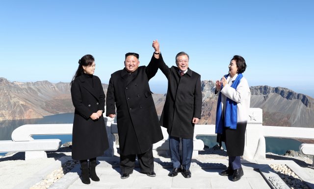 20일 오전 문재인 대통령과 김정은 북한 국무위원장이 백두산 정상인 장군봉에 올라 손을 맞잡아 들어 올리고 있다. 김정숙 여사와 리설주 여사도 함께 했다.2018.9.20/뉴스1 © News1 평양사진공동취재단